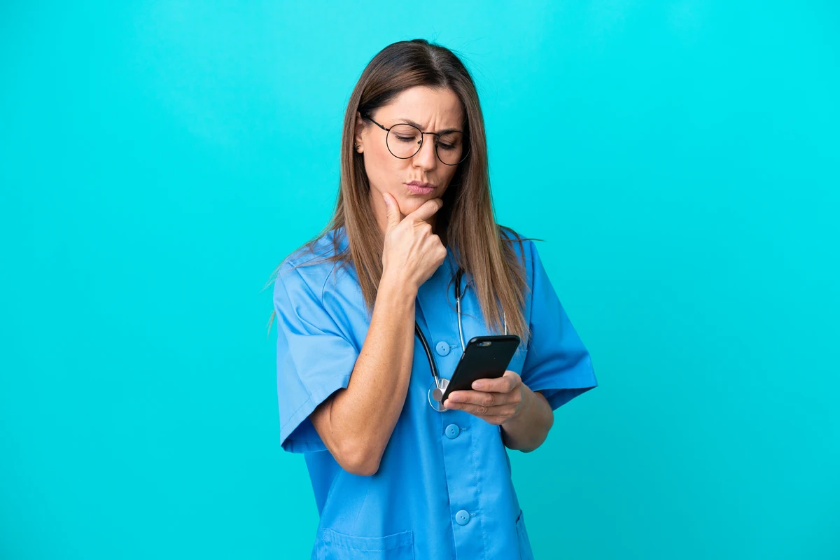 Femeie în uniformă, gândindu-se la telefon.